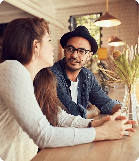 Man and woman sitting and talking at counter by window