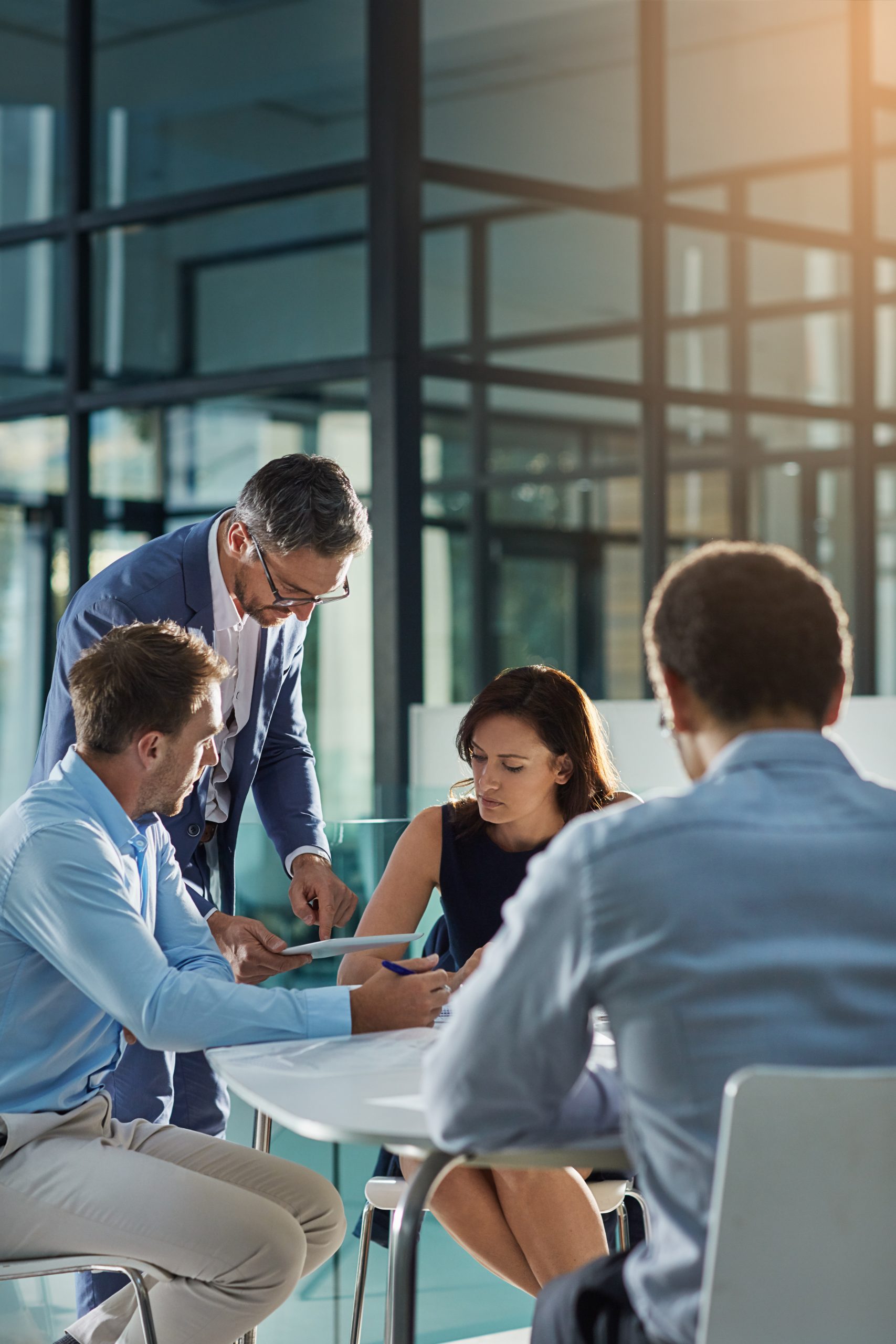 Man, tablet and business people in meeting for coaching, goals and mission at desk for discussion. Teamwork, woman and strategy for vision, collaboration or innovation in financial company with coach.